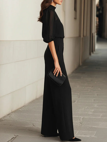 Conjunto de tres piezas en negro, compuesto por un top sin mangas transparente y unos pantalones de pierna ancha